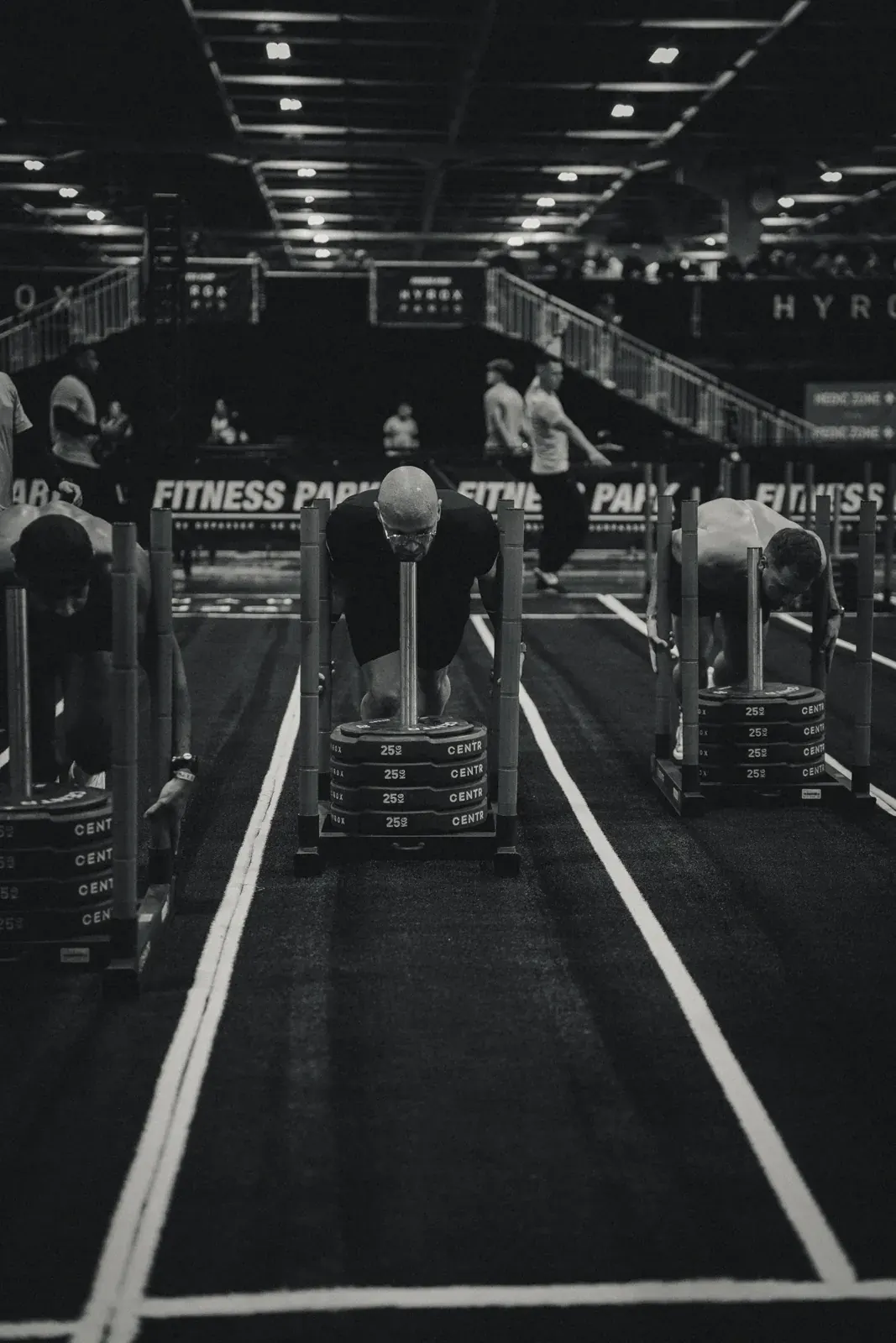 Couloirs de sled push encore vides avant une course Hyrox, en noir et blanc